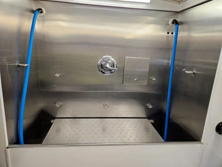 Wide view of the raised grate inside the stainless-steel grooming tub in the Green Dog Mobile Grooming van