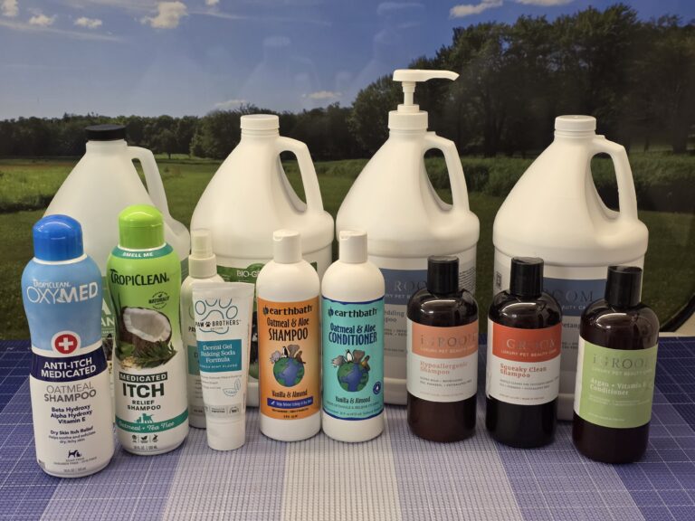 Assorted professional dog shampoos and conditioners arranged on a grooming table